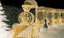 little girl near the huge lightened train at the Enchant Christmas village