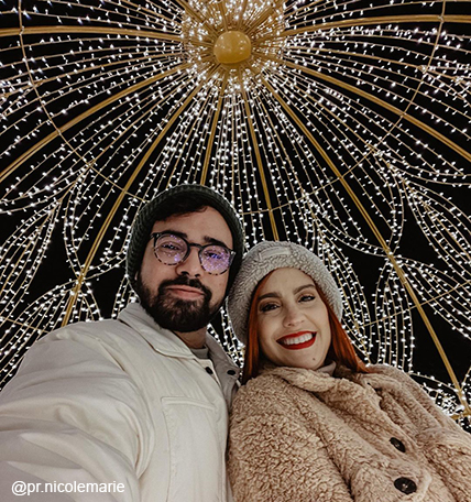 couple posing under the light dome at the enchant christmas village