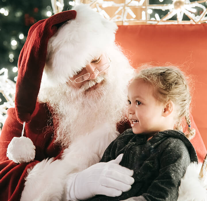 santa and a little girl chatting at enchant christmas village