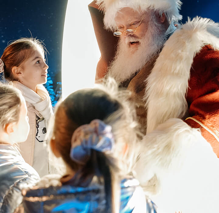 Santa reading books to kids at Enchant Christmas